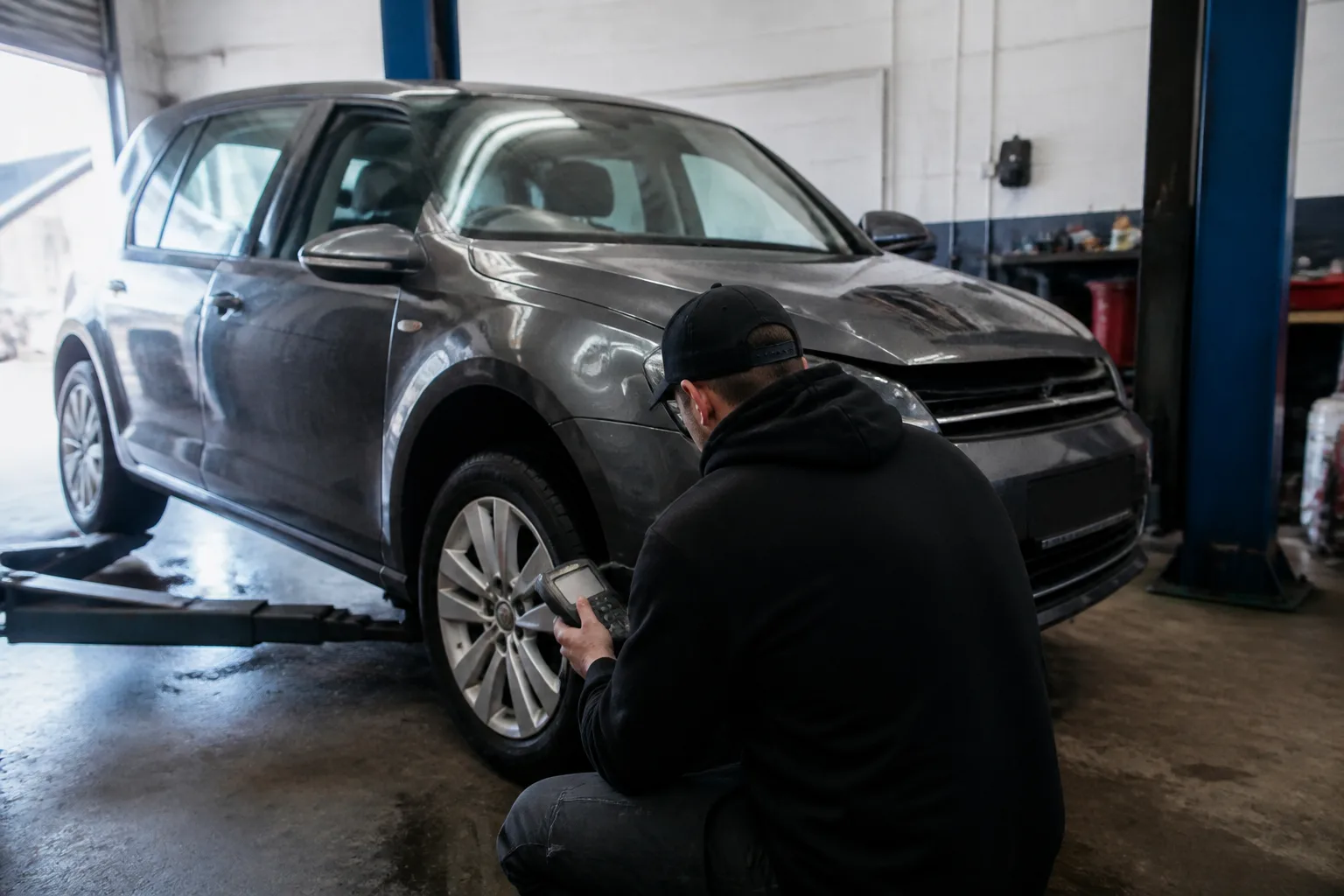 Mechanic checking a family car during a fuel economy inspection in an independent UK garage