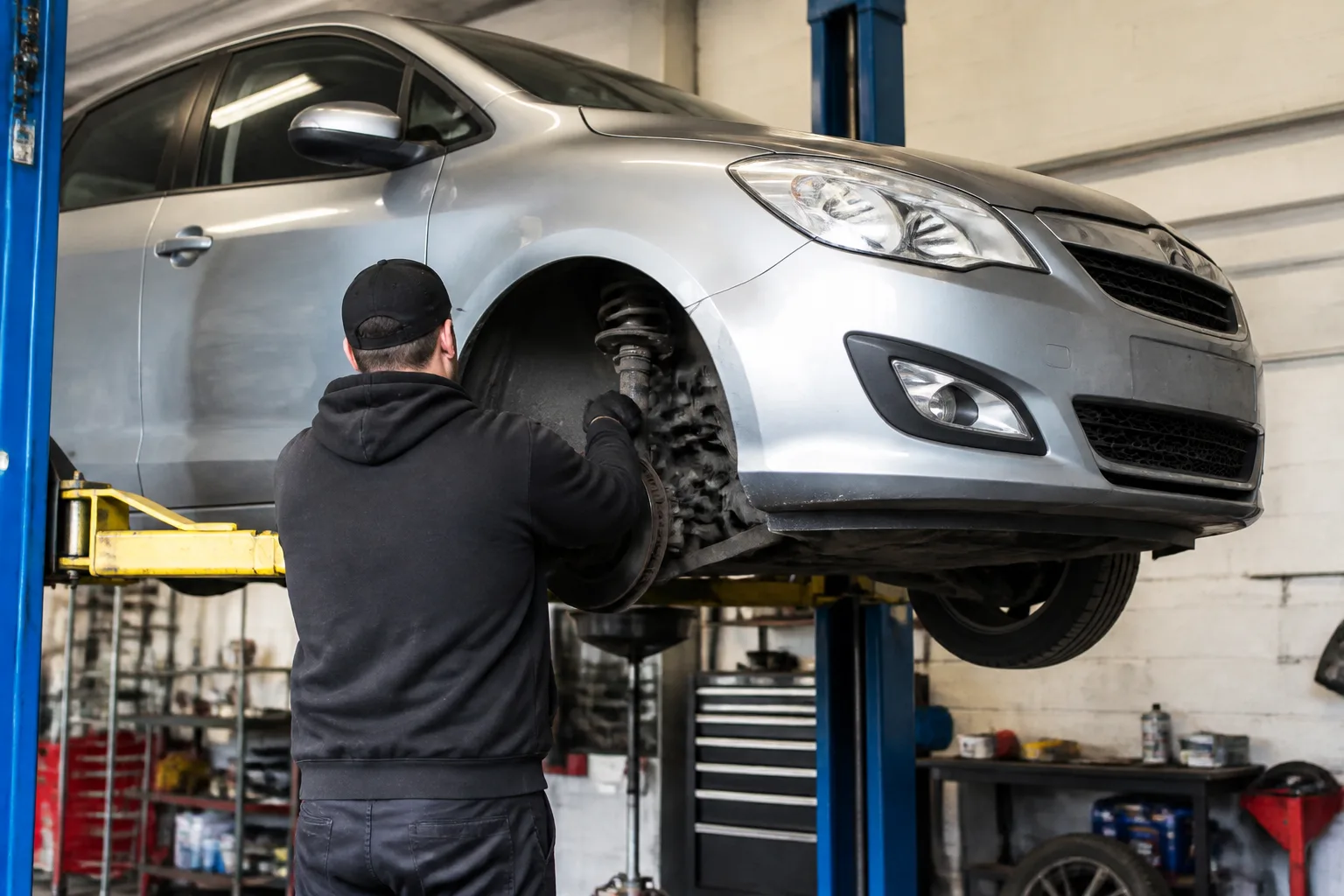 Mechanic inspecting the suspension of a family car in an independent UK garage