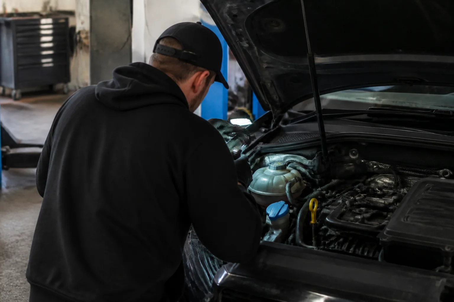 Mechanic safely inspecting the coolant system of a car in an independent UK workshop